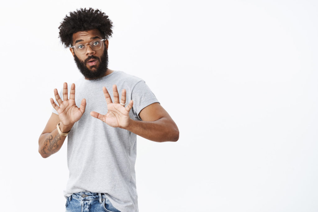 Man raising hands in warning: avoiding scams when selling a private mortgage note