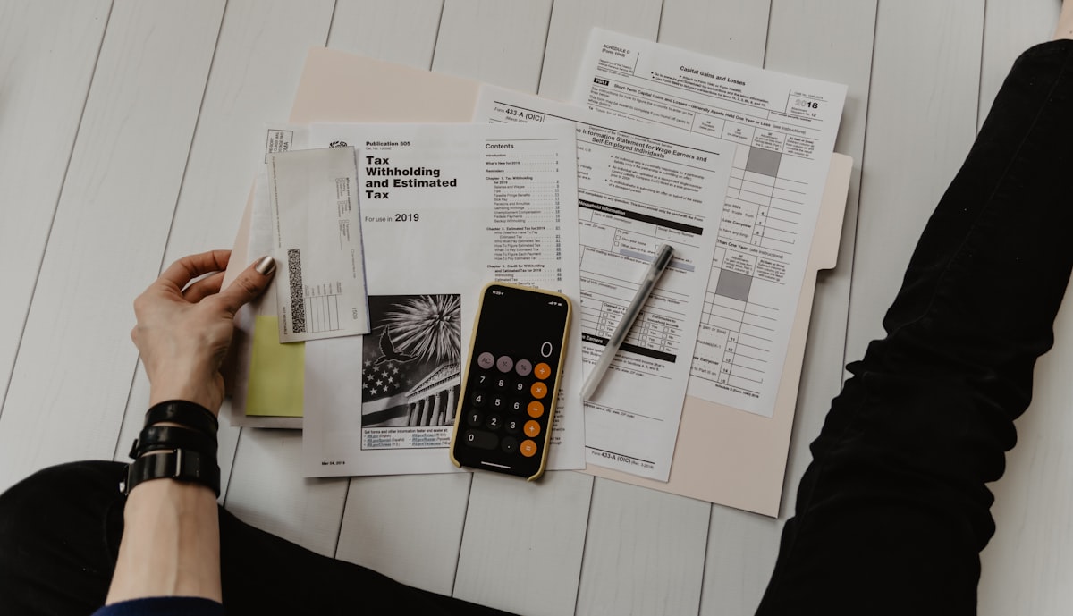 Tax documents and calculator — understanding tax implications of selling a mortgage note